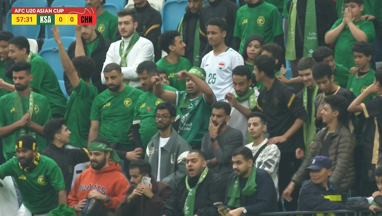  看臺沙特球迷目睹主裁判給中國隊點球，比劃手抗議示意看VAR